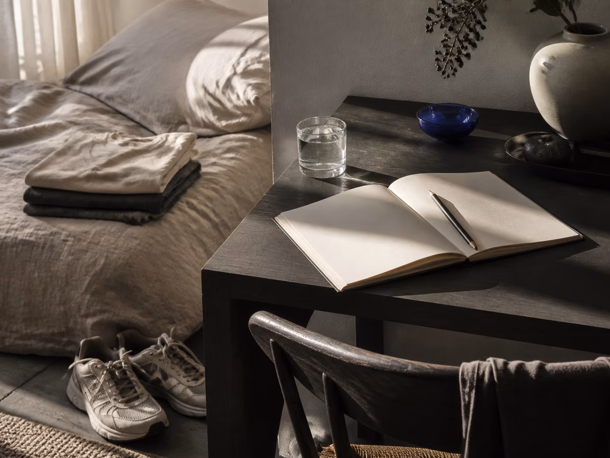 A calm morning setup with running shoes, water, and an open notebook.